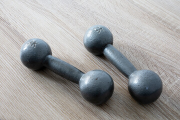 Old iron dumbbells on a wooden floor