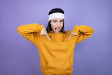 Young latin woman wearing sportswear over purple background confident with smile on face, pointing oneself with fingers proud and happy.