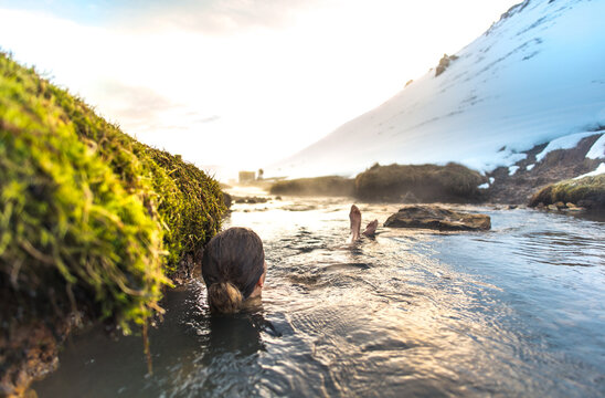 Woman relaxing in Reykjadalur geothermal river in Iceland