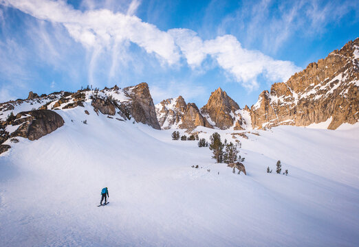 Man skiing towards snowy mountain during sunrise in California