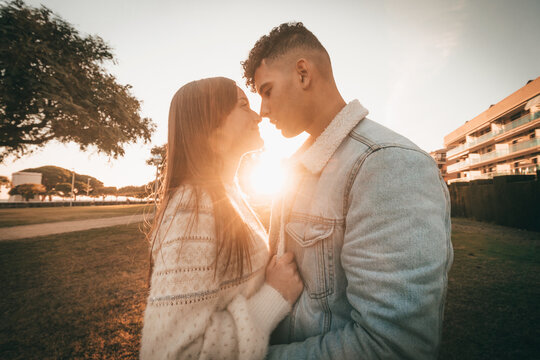 Profile Shot Of A Couple Embracing With Sunlight In The Center Of Them