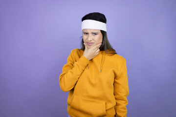 Young latin woman wearing sportswear over purple background touching painful neck, sore throat for flu, clod and infection