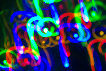 Bokeh blue background. Bright festive multicolored circles and lines in motion. Defocused abstract colorful lights 