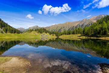 Fototapeta na wymiar Idyllic mountain lake with some huts on an alp in Austria