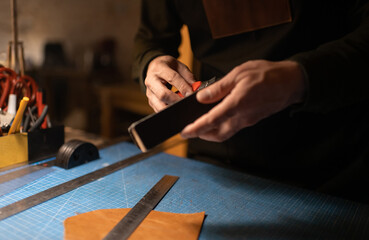 Cropped artisan sharpening knife in workshop