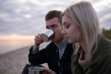 Man drinking tea near girlfriend in countryside
