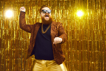 Happy funny bearded young man in crazy outfit dancing gangnam style and having fun on stage at...