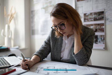 Thoughtful female architect examining draft