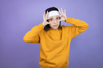 Young latin woman wearing sportswear over purple background Trying to open eyes with fingers, sleepy and tired for morning fatigue