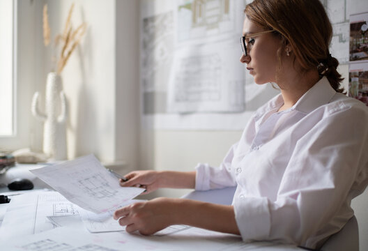 Attentive businesswoman reading draft in office