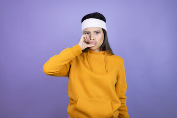 Young latin woman wearing sportswear over purple background mouth and lips shut as zip with...