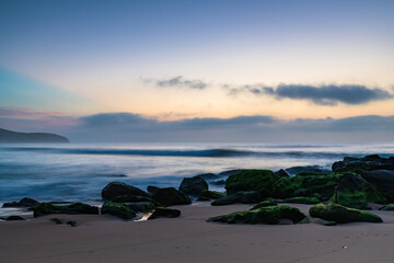 Obraz na płótnie Canvas Beautiful sunrise with high cloud and headland at the seaside