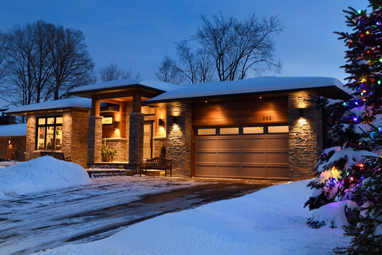 Snow covered modern house in Ontario Canada with Christmas lights in winter