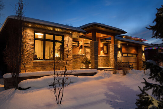 Fresh snow on modern house in winter at twilight