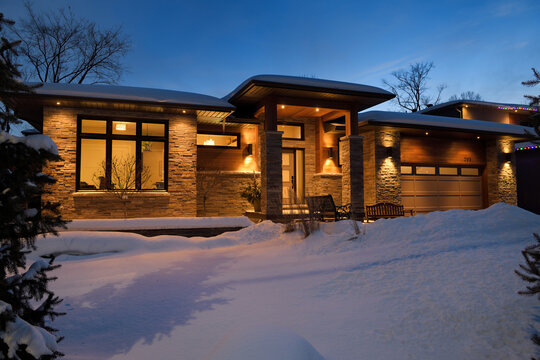 Snow covered front yard of modern house in Ontario Canada at twilight