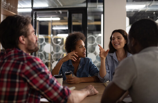 Happy lady speaking with multiethnic colleagues
