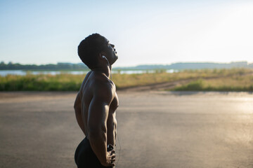 Muscular sportsman resting by road