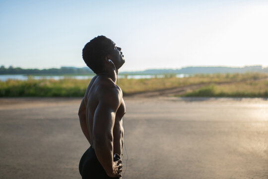 Muscular sportsman resting by road