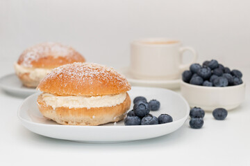 Traditional Scandinavian sweet buns for Shrove Tuesday with blueberries and a cup of coffee.