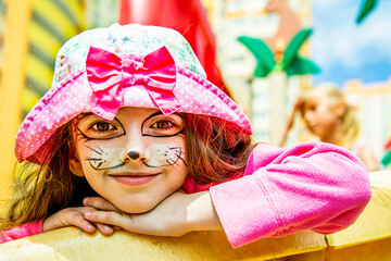 portret of girl in pink clothes with a kitten face painting