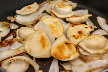 Pierogi and onions in a fry pan