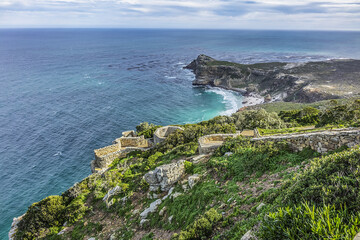 Rugged rocks and steep cliffs of Cape Point in the Cape of Good Hope Nature Reserve on the southern tip of the Cape Peninsula in South Africa. The Atlantic and Indian oceans converge at Cape Point.