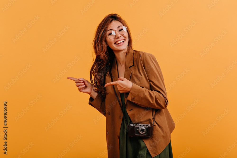 Canvas Prints positive girl in oversize trench coat happily with cheerful smile shows to side. snapshot of europea