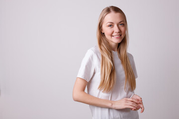 The girl is happy in a white T-shirt on a white background. emotions of joy