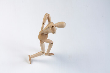 a bent wooden mannequin suffering from back pain