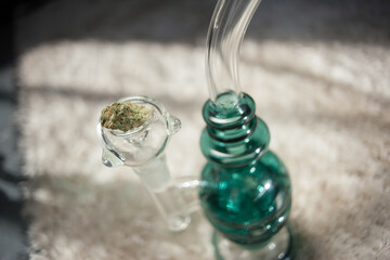 Brand new clean glass water pipe or bong for smoking legal strains of indoor grown commercial farming marijuana, weed, cannabis buds for medical and recreational use among adults nationwide