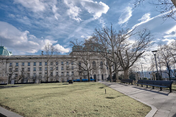 Fototapeta premium Sofia university view from small cute city park with sunshine coming from clouds. Bulgaria. Sofia. 06.01.2021.
