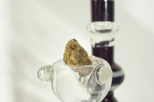 Marijuana abuse on the rise as legalization decriminalization and prohibition ends across states nationwide. A dried bud of herb sits in a glass bowl hitter pipe for recreational smoking