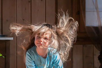 Mädchen mit fliegenden Haaren über einem Staubsauger