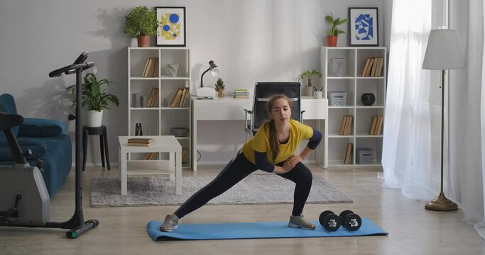 Aerobics And Gymnastics Training At Home, Teen Girl Is Crouching On Legs On Sides, Fitness In Living Room