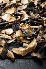 Mix of chopped wild dried mushrooms, on old dark  wooden table background