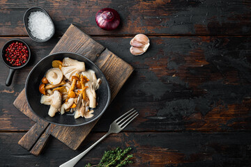 Wild mushrooms Boletus edulis and cap boletus in a jar, on old dark  wooden table background, top view flat lay , with space for text  copyspace