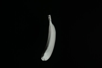 White floating banana on a black background. Front side. Creative fruit concept