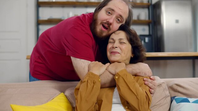 Portrait of grateful adult man hug smiling middle-aged mother show love and care