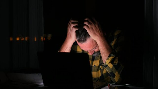 Tired and frustration man working and using laptop at late night. Business man upset to have work too much 
