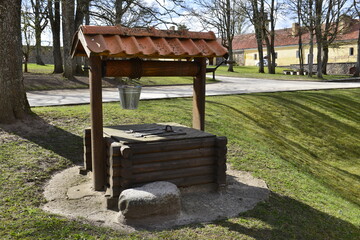 Old device for bucket or draw well for  output of drinking water in old public park and museum, spring time