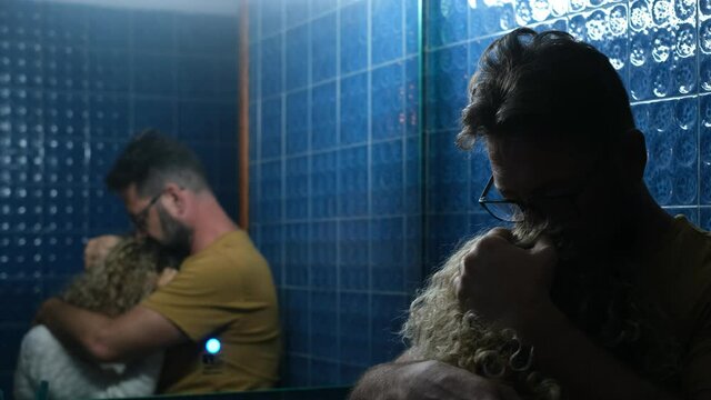 Portrait of one couple of two sad and unhappy woman and man hugging in the bathroom reflexing and consoling together. Relationship with money and economic problems.
