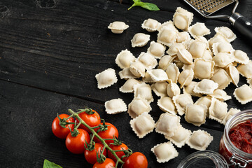 Ravioli with Parmesan and Basil, on black wooden table background , with copyspace  and space for text