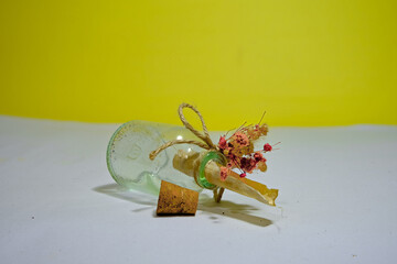 A piece of papyrus paper inside the glass pod and wood plug on white ground and yellow background....