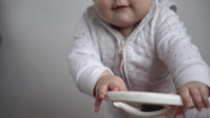 Childhood, entertainment, games, transport, motherhood concepts - active happy smiling joyful chubby infant baby kid child 10 months play ride big toy plastic red car scooter and beeps at home indoors