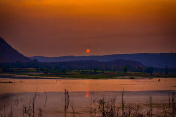 The sun is rising in the morning over the mountains in Thailand.