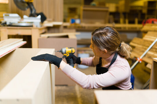 Female worker doing woodworking in her workshop