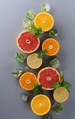 Creatively laid out citrus fruits on gray background. Top view of oranges, lemons, tangerines, grapefruit.Preparation of drinks. Citrus juice ingredients, food background