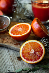 Blood orange halves with fresh juice in glasses on background on wooden table.