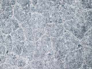 The texture of the old asphalt. Long-standing road paving. Background with irregularities and coarse grain.
