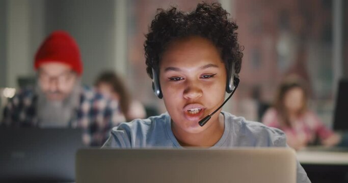 Call center agent with headset working on support hotline in modern office